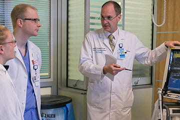 Physician and med students in hospital room 