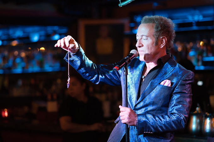 sidney friedman performs on stage in a tuxedo