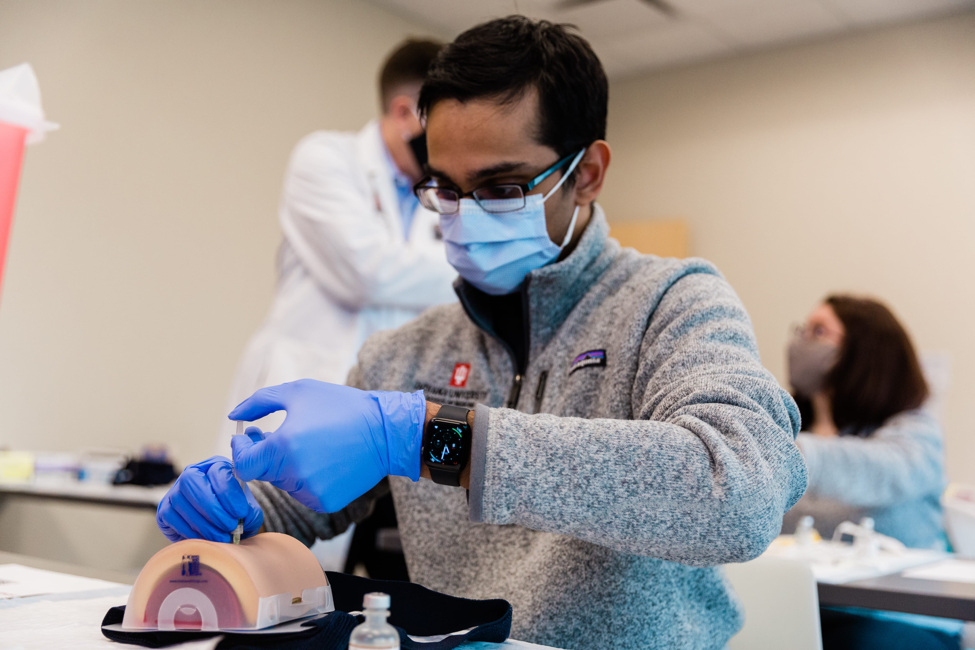 Medical student practices giving a vaccine on a simulator