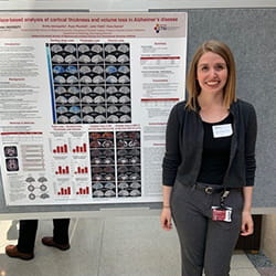 emily stands in front of her research poster