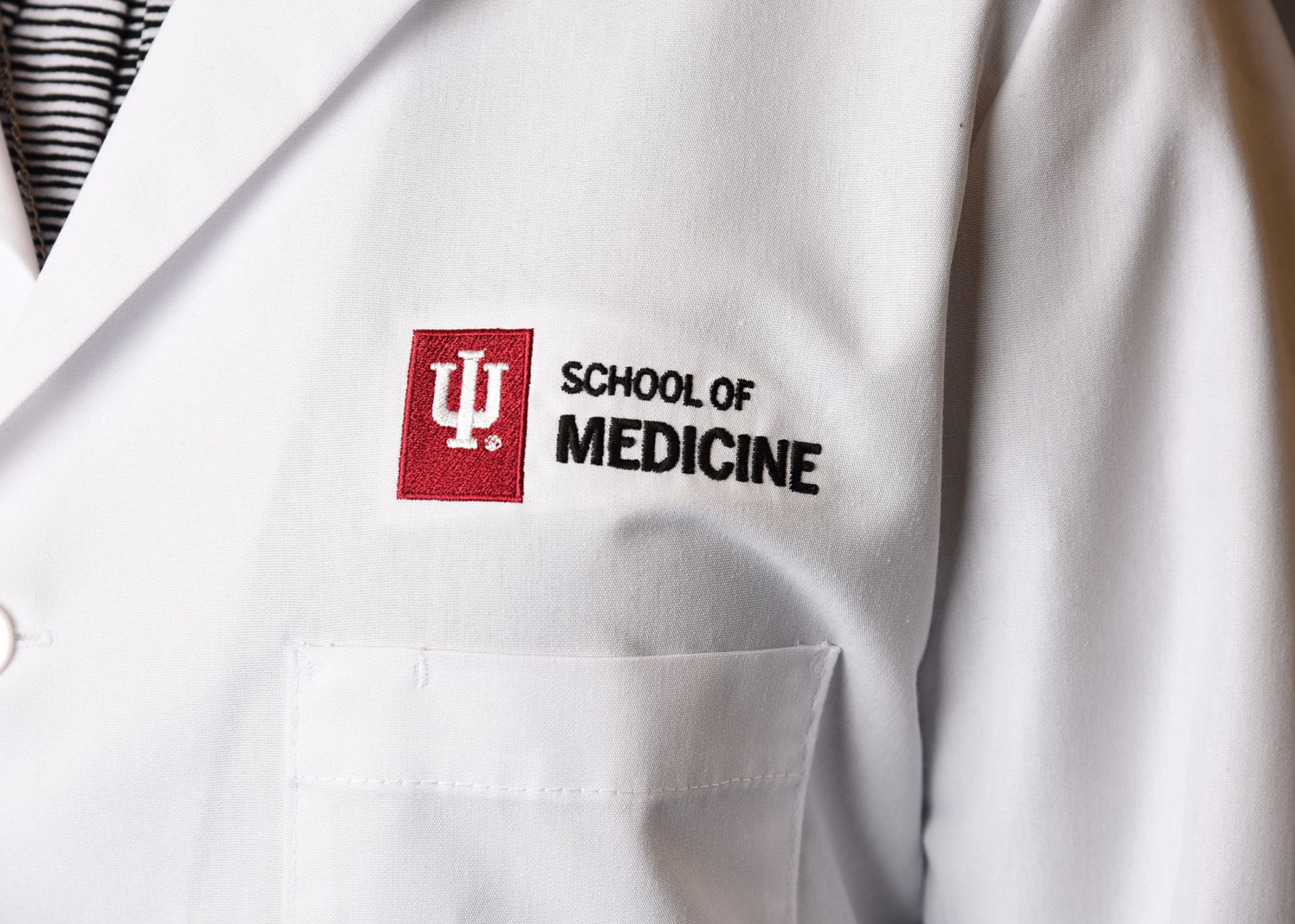 close up photo of a white coat with "IU School of Medicine" embroidered on the right side