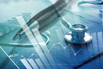 stethoscope, pen and notepad with graphing lines