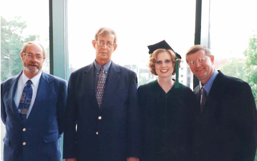 Carmella Evans-Molina at graduation with her dad and uncles