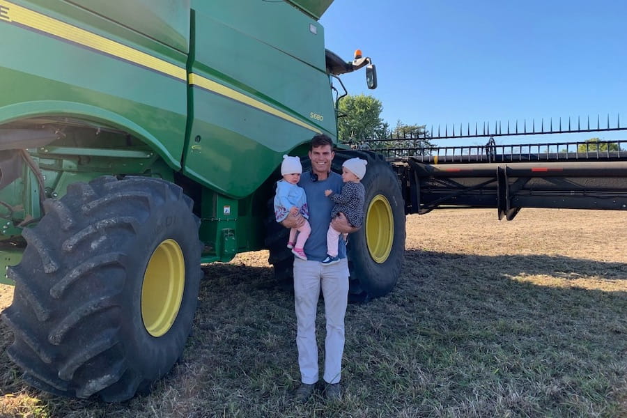 Jay Fiechter on the farm with his twin daughters