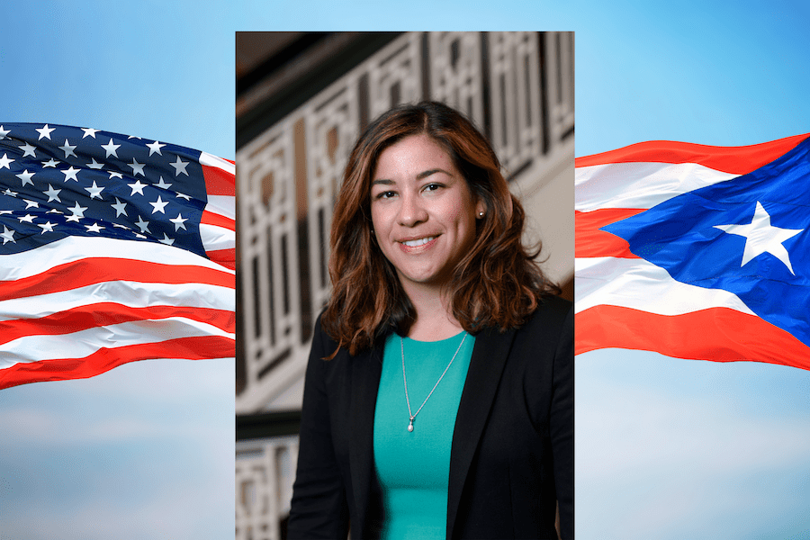 Sylk Sotto with American and Puerto Rican flags in background