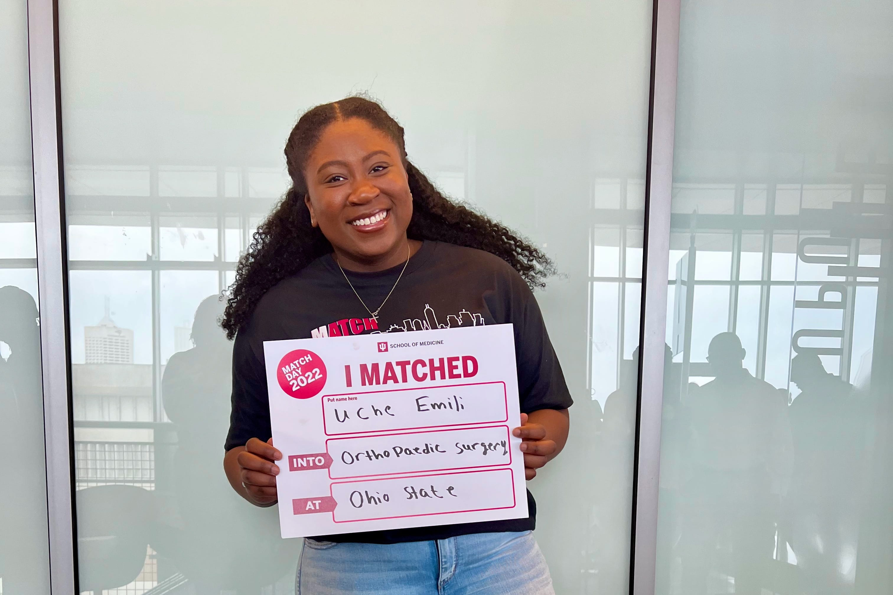 Uche Emili holding Match Day sign