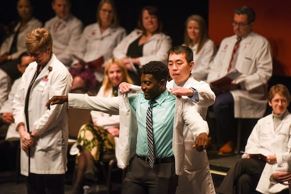 Medical student putting on white coat