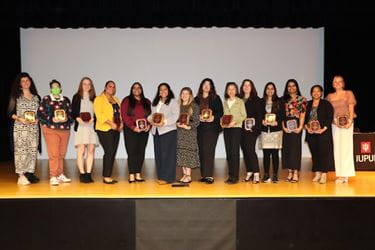 Award winners on stage with plaques
