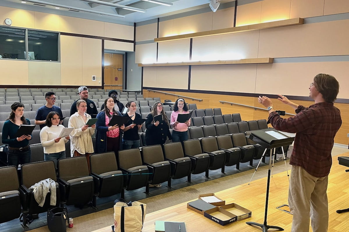 Gavin Craig conducts the choir during a rehearsal