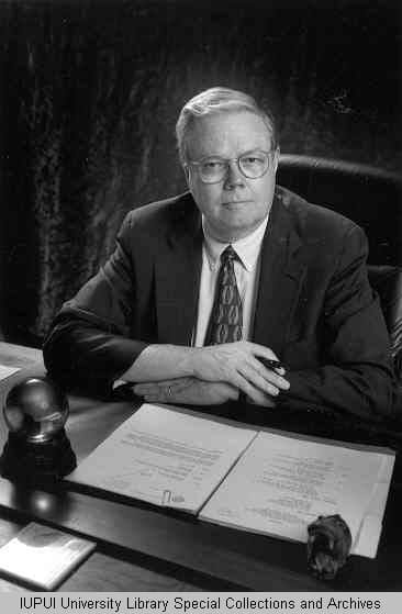 Black and white photo of Walter Daly at his desk in 1983