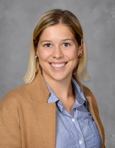 Professional headshot of Morgan Black (caucasian female with blonde hair) on blue background