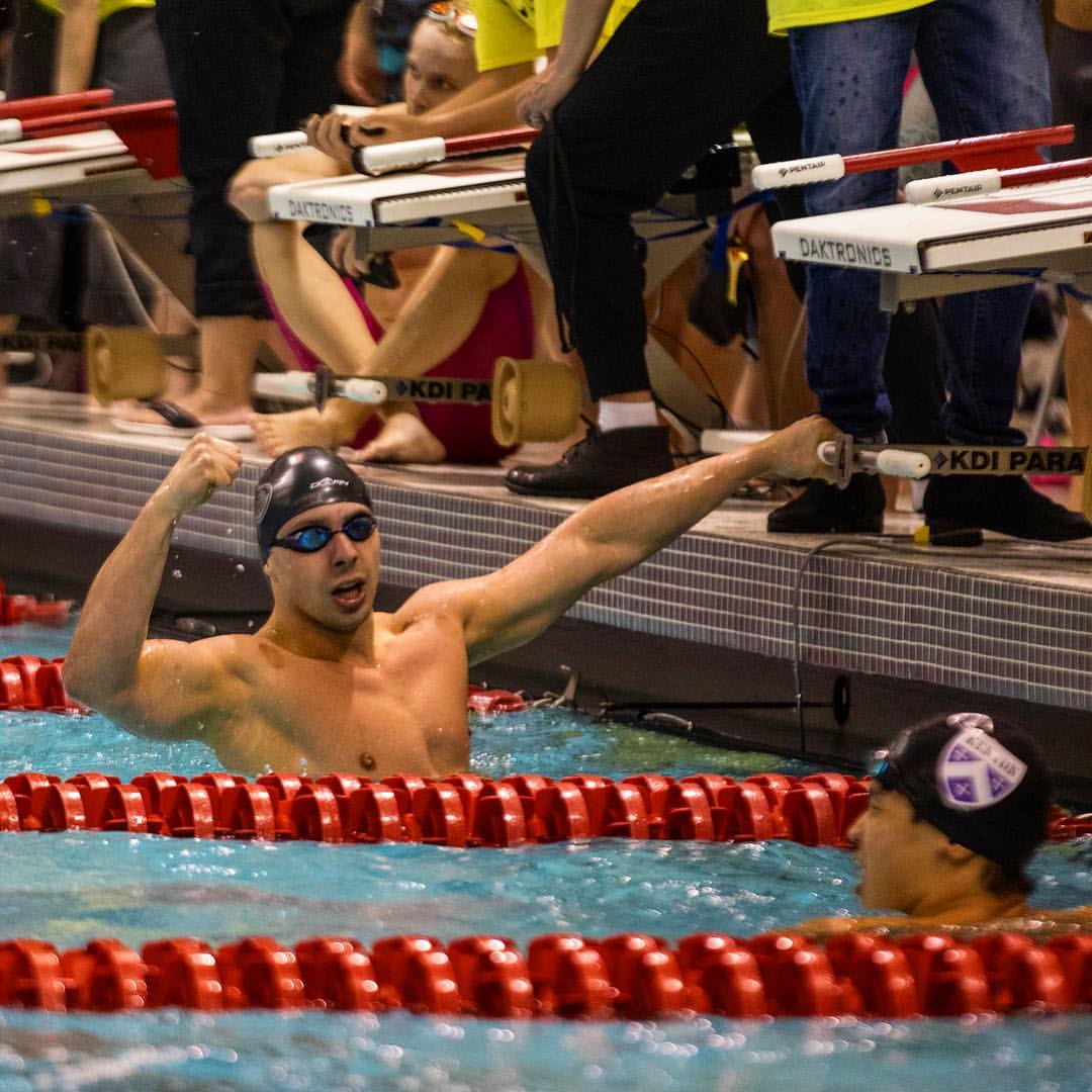 Zach Wagner in the pool wearing swim cap during a competitive meet