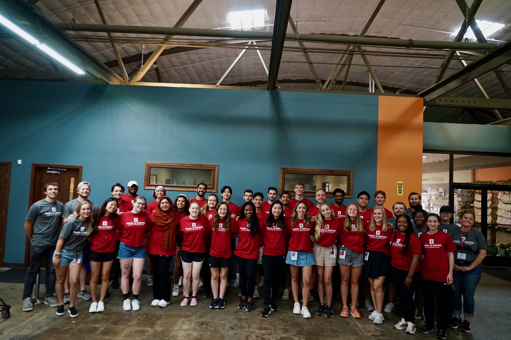 a huge group photo of students standing with their arms around each other after working at the food bank in gary