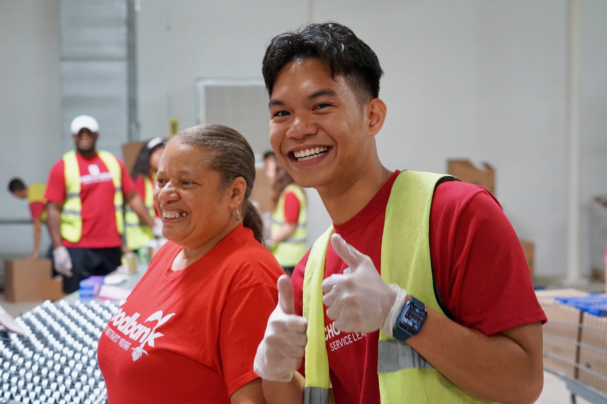a student gives two thumbs up while working at the food bank in Gary.