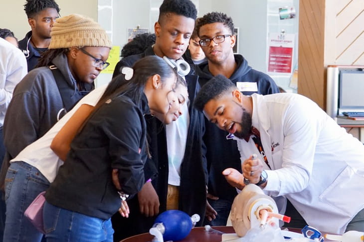 a student teaches high school students at a hands-on learning event in Gary