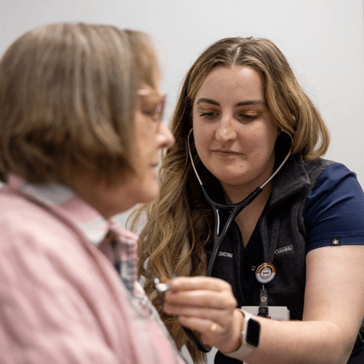 An IU medical student listens to a patient's chest with a stethoscope.