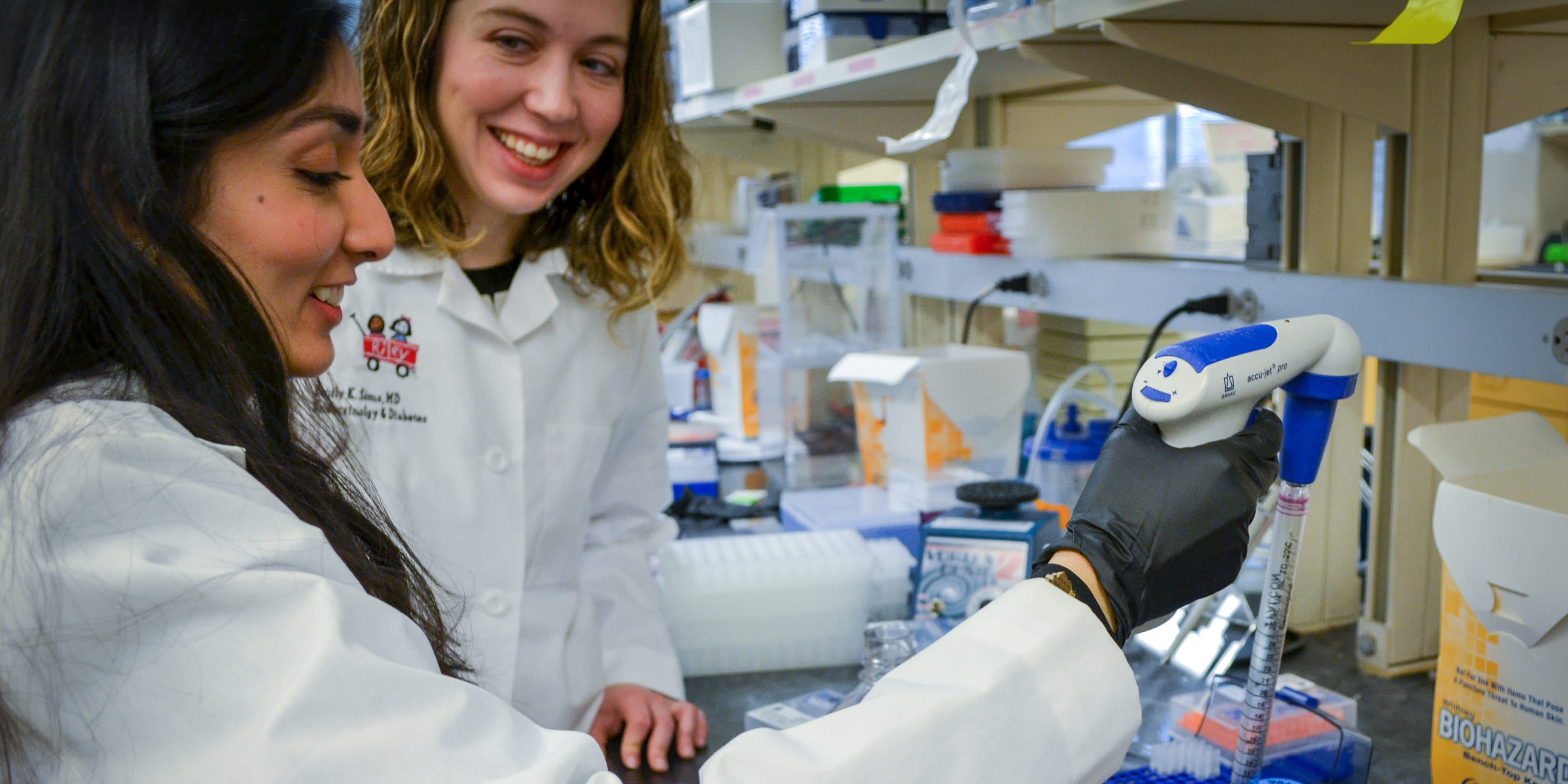 Dr. Emily Sims and Dr. Sara Ibrahim working in a laboratory.