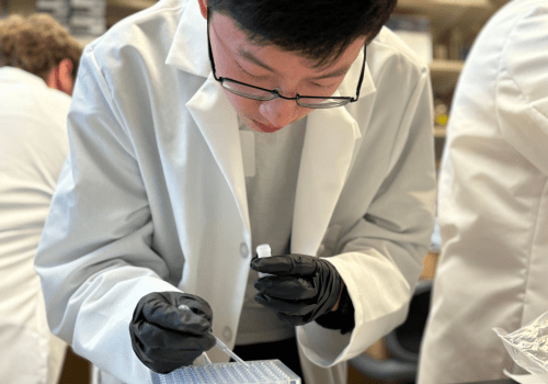 close up photo of Owen Nichols pipetting in a lab