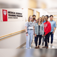 students in front of MSTP sign