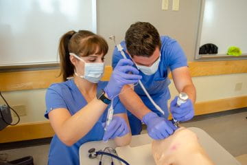 Two people performing a simulated intubation. 