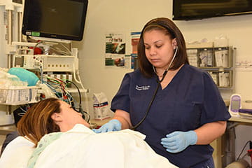A medical student utilizes a stethoscope on a patient.