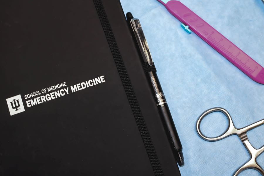 close up photo of a notebook and basic emergency medicine tools