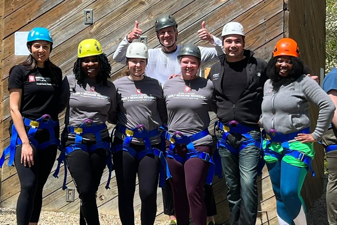 family medicine residents from IU Health Arnett wearing climbing harnesses and helmets at a wellness event