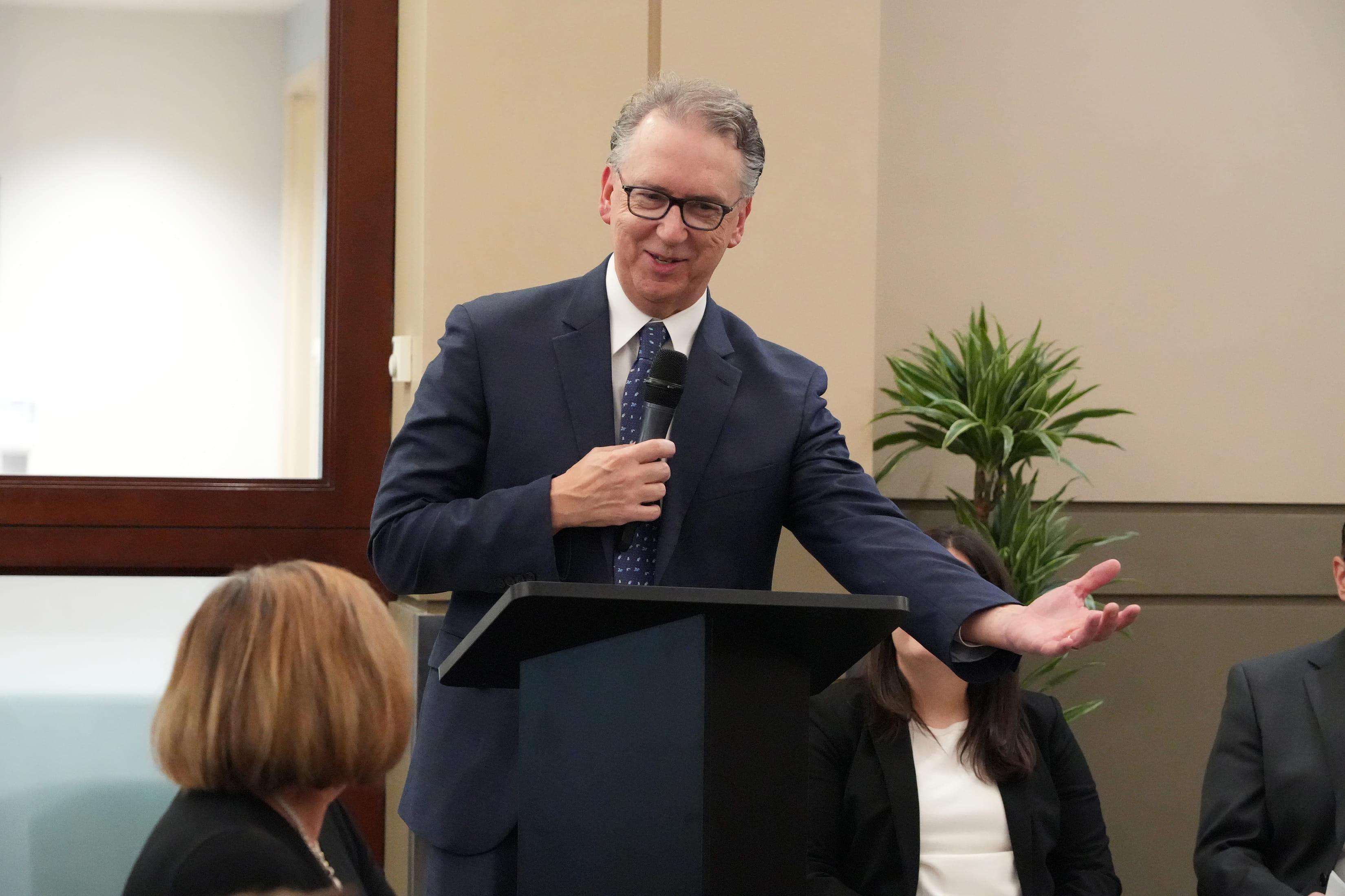 Douglas Rex, MD, holding a microphone and standing behind a lectern, addresses the audience of his Sagamore of the Wabash celebration.