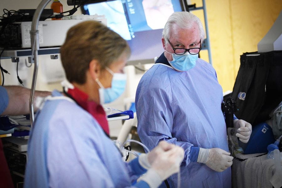 Photo of Dr. Lehman in the endoscopy suite during a procedure talking to a colleague.