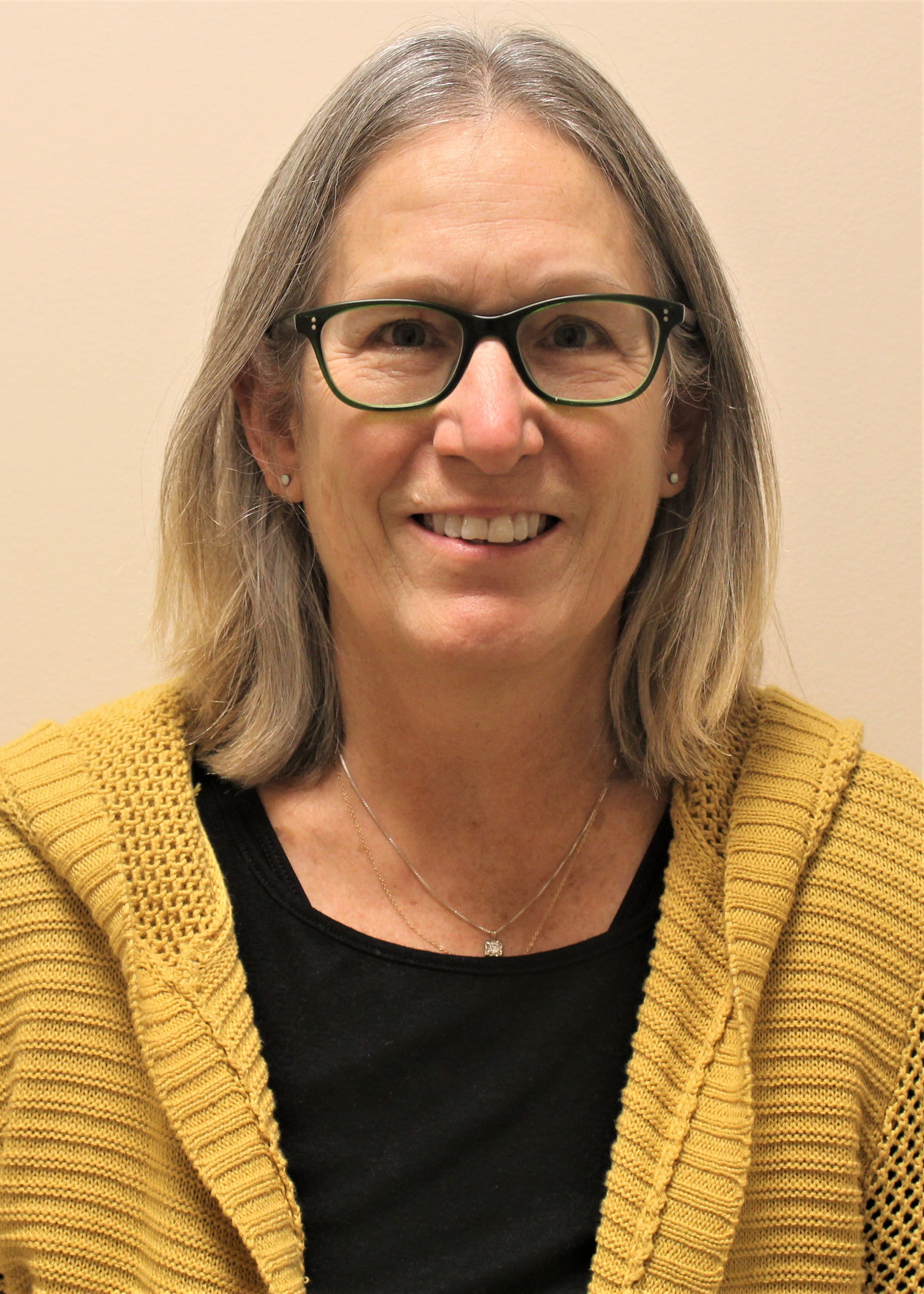 Sue Samson wearing glasses and a yellow sweater