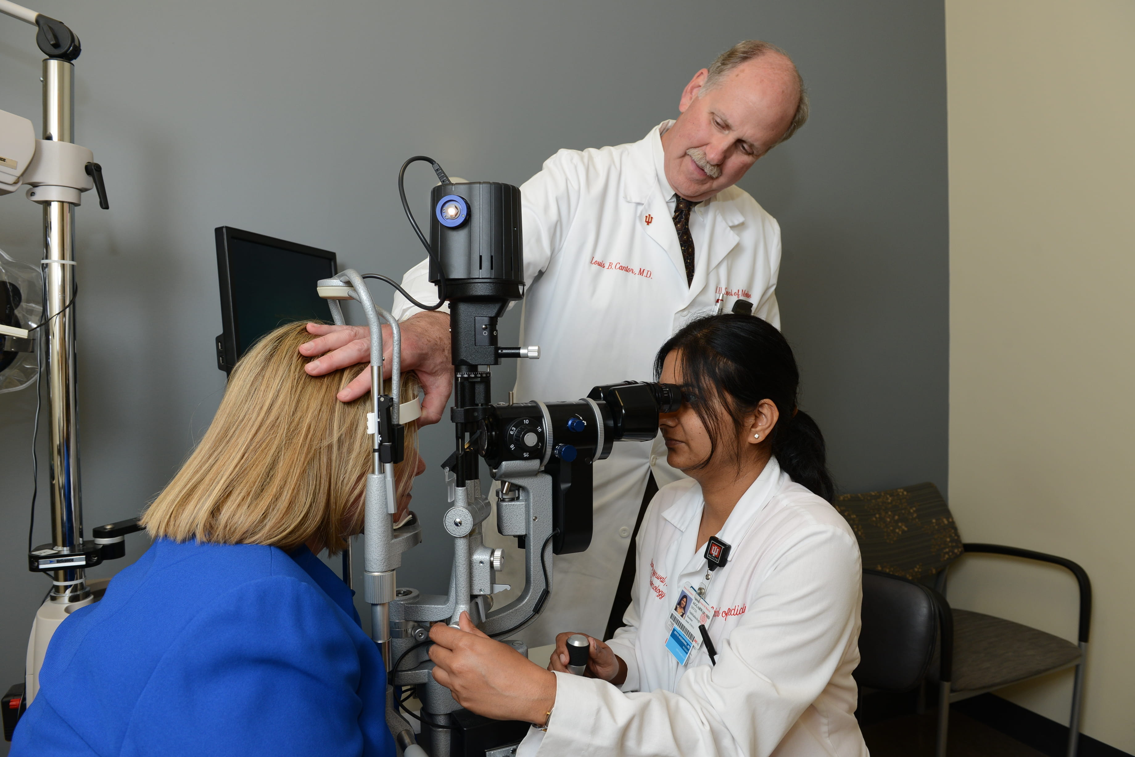 Dr. Louis Cantor instructs a student as she conducts an eye exam on a patient. 