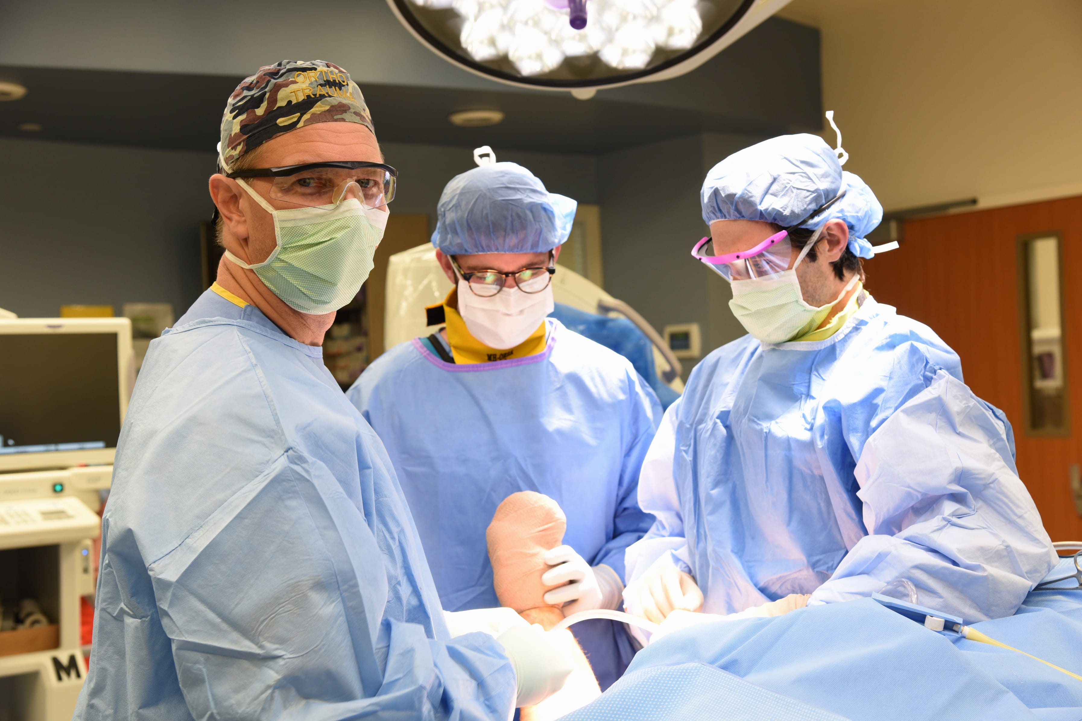 Dr. Brian Mullis working in the operating room with two residents
