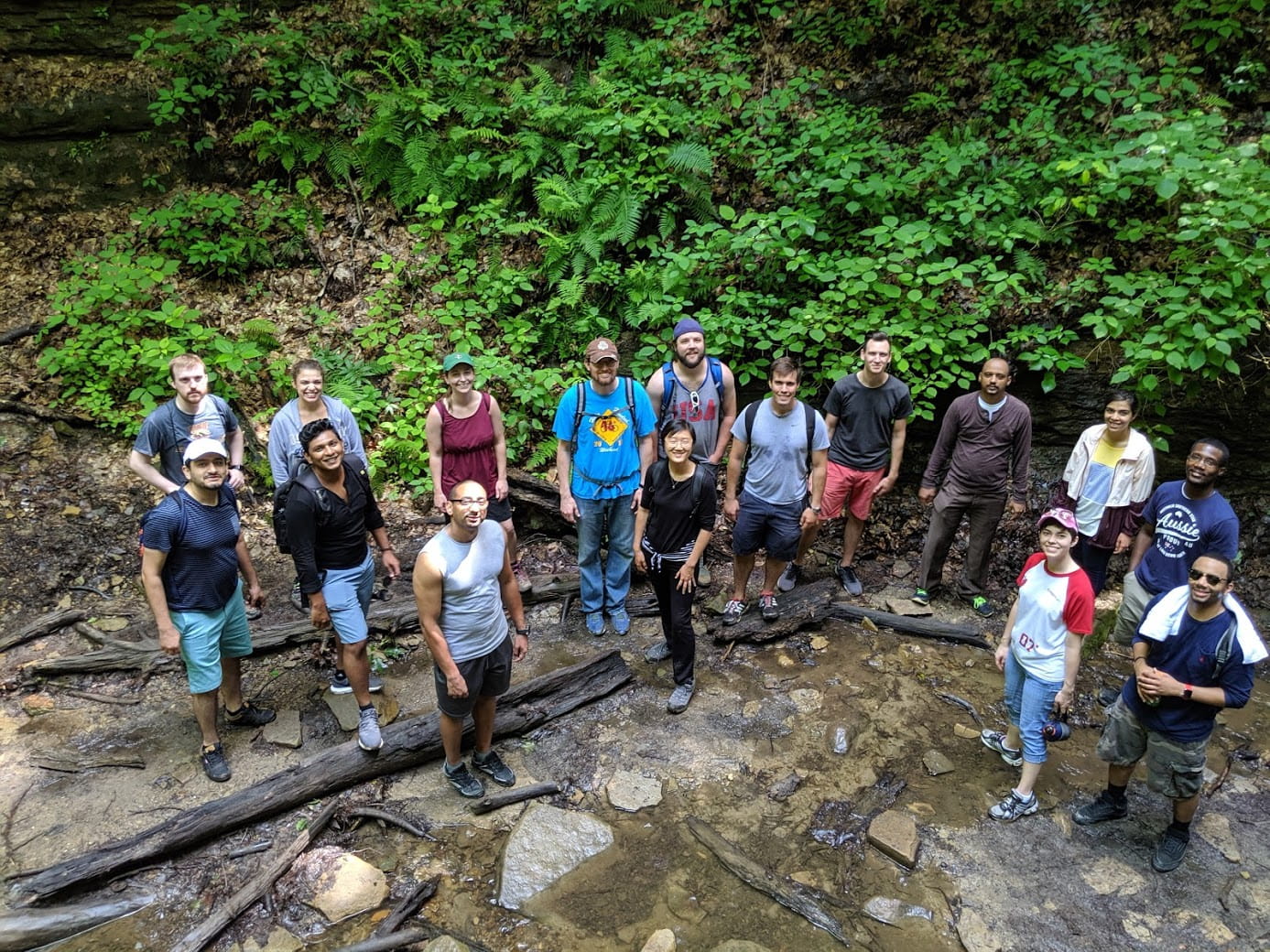 residents hike by a creek in the woods