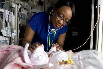 a provider plays with a baby in the hospital