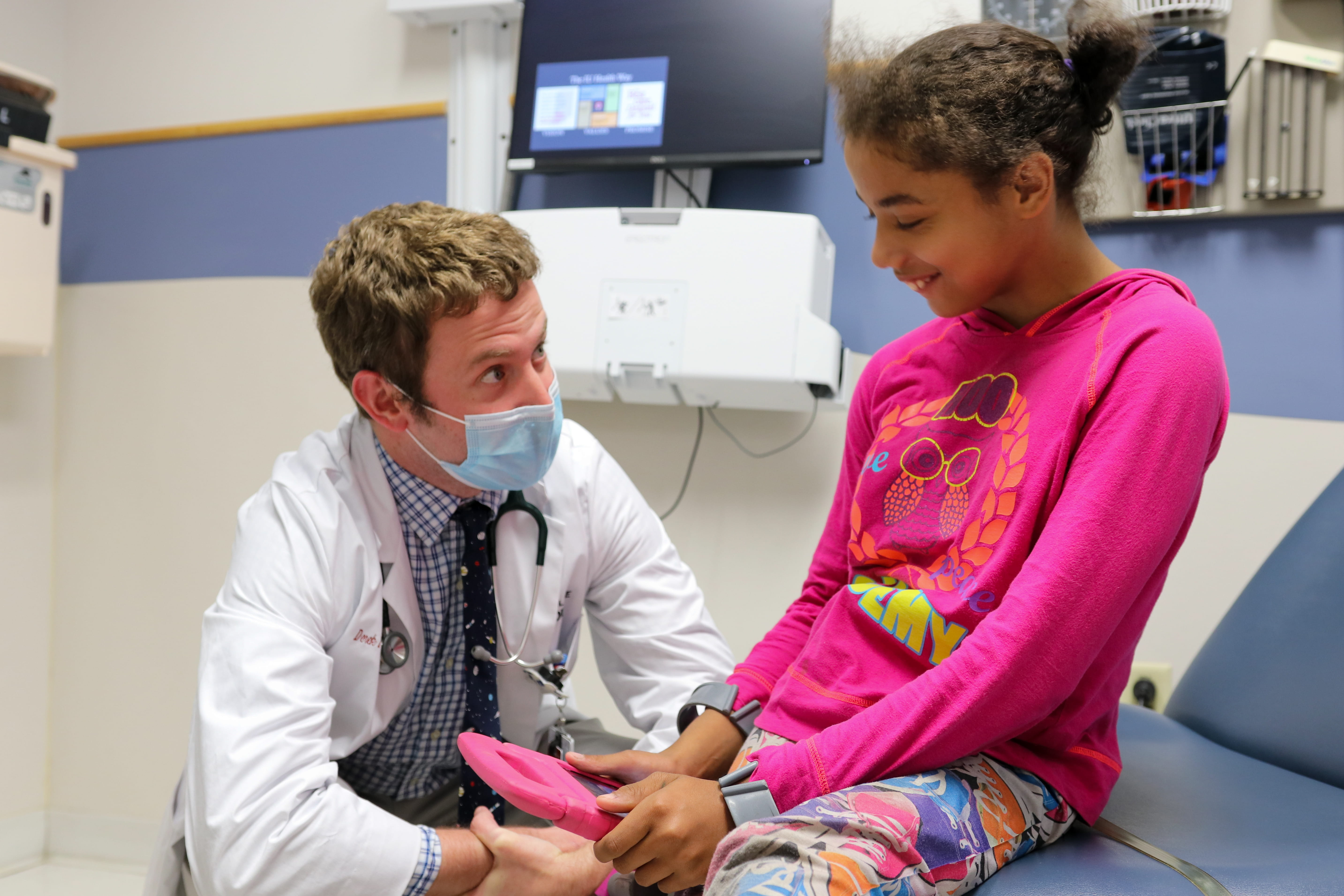 A fellow speaks with a patient in the clinic