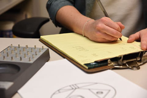 a person writes on a clipboard