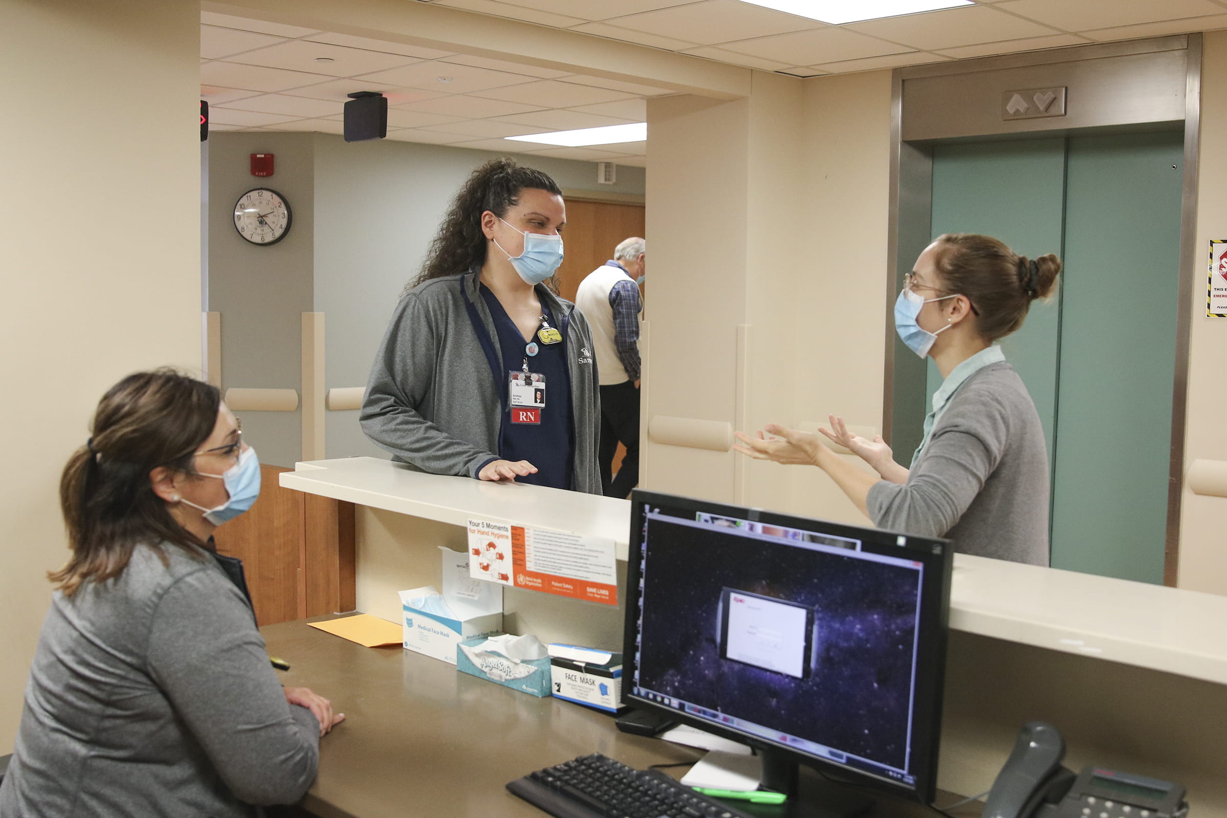 Nurses and doctors talking by counter in hospital 