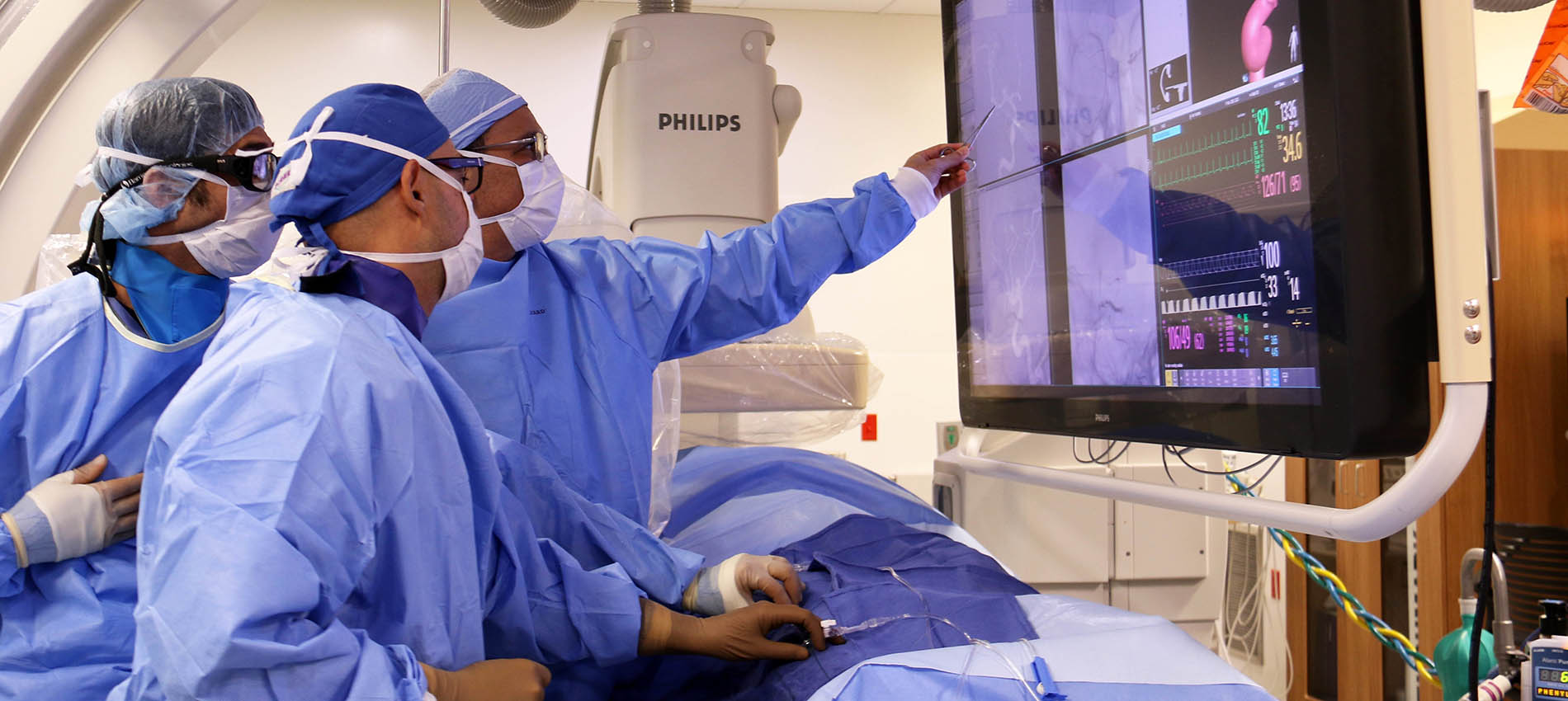 three radiologists examine and discuss imaging results