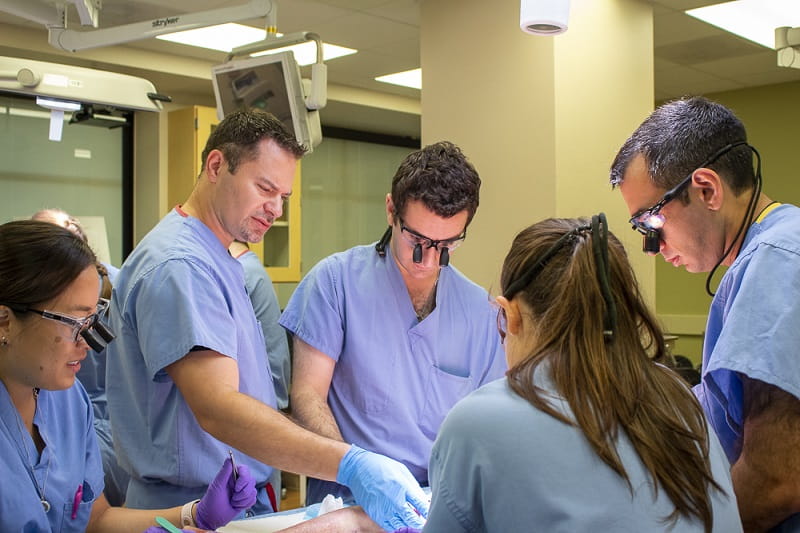 Residents practicing surgery during a cadaver lab