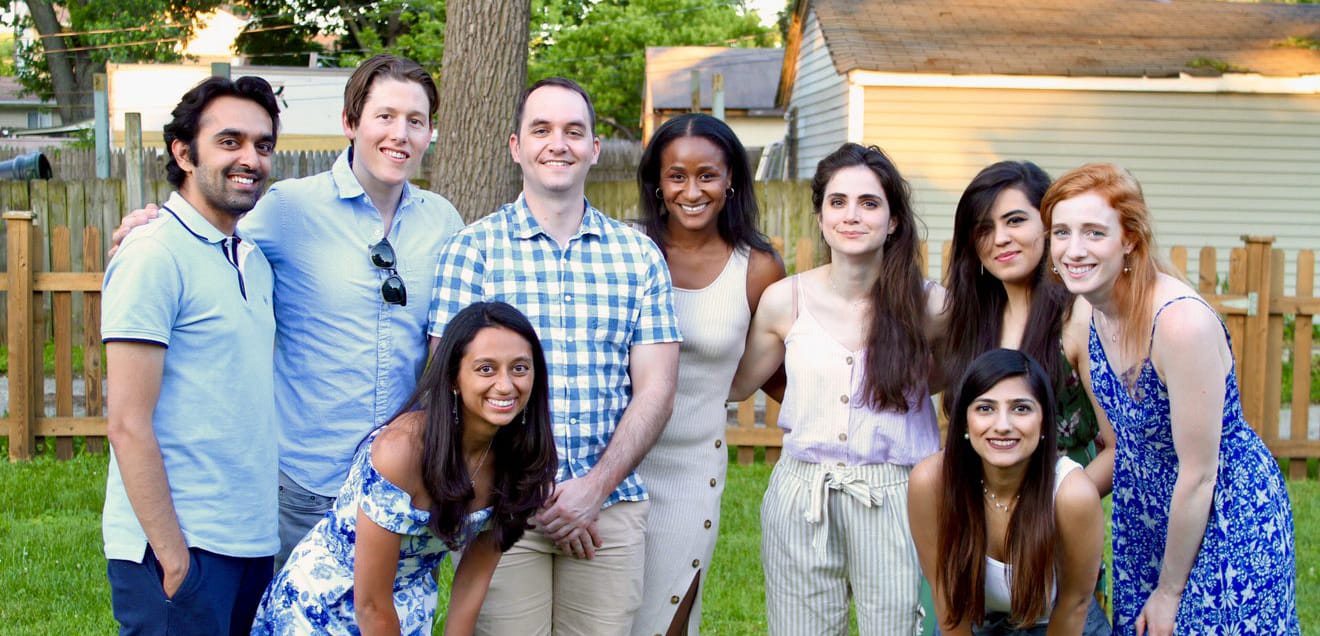 a diverse group of residents smile with their arms around each other on a sunny summer day in Indianapolis 