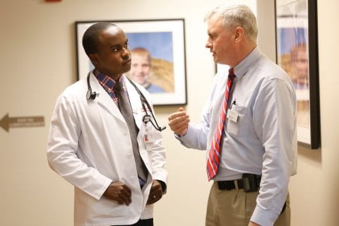 a student and faculty member speak together in the clinic