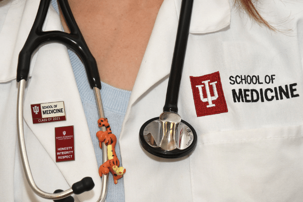 Individual with white coat and stethoscope