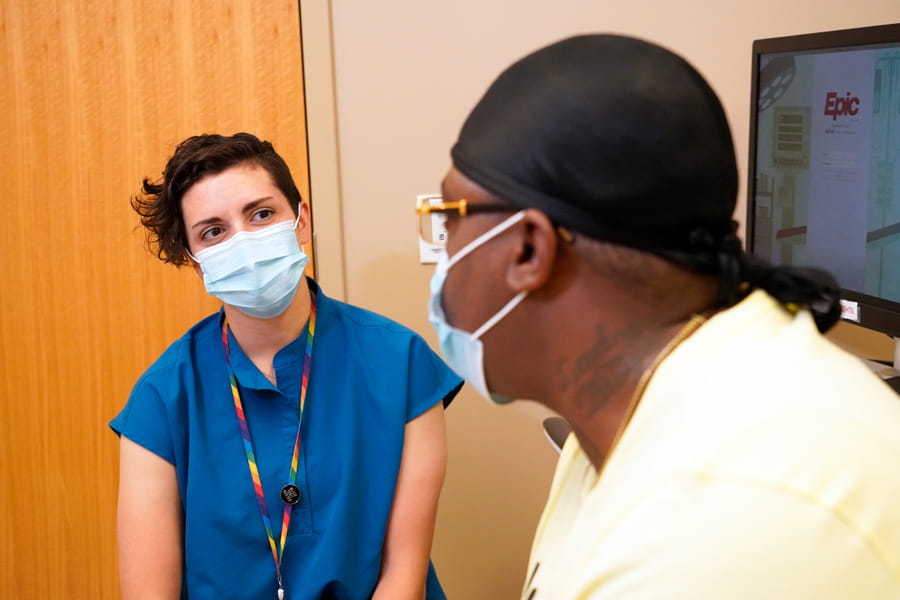 hannah locke speaks with a patient in clinic