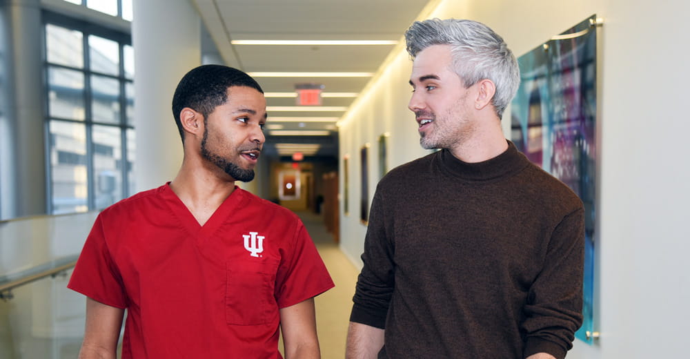 a provider and patient walk down the hall talking to each other