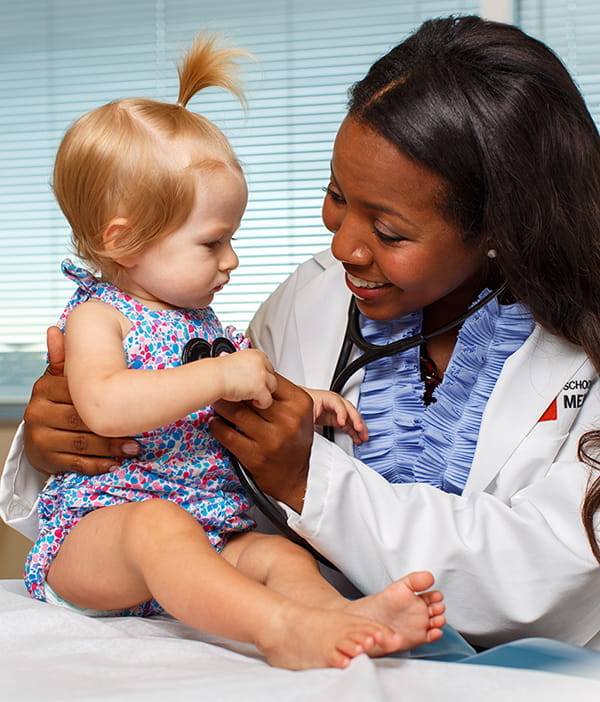 A fourth-year medical student examines a young girl in a doctor's office
