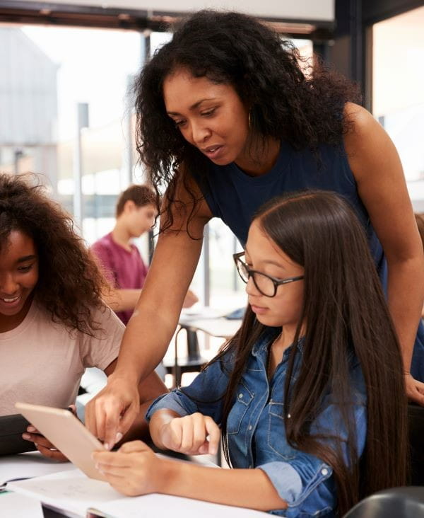 a teacher looks at a student's work in class