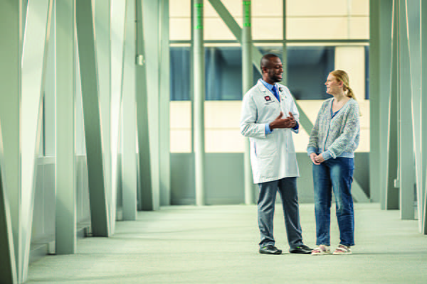 A cardiovascular medicine physician talks with a patient or student in a hallway