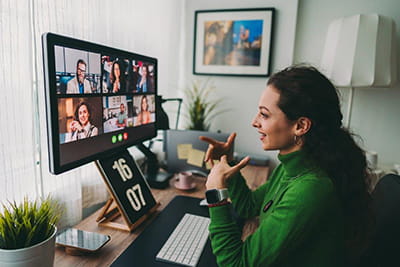 A woman engages with several others on a video call