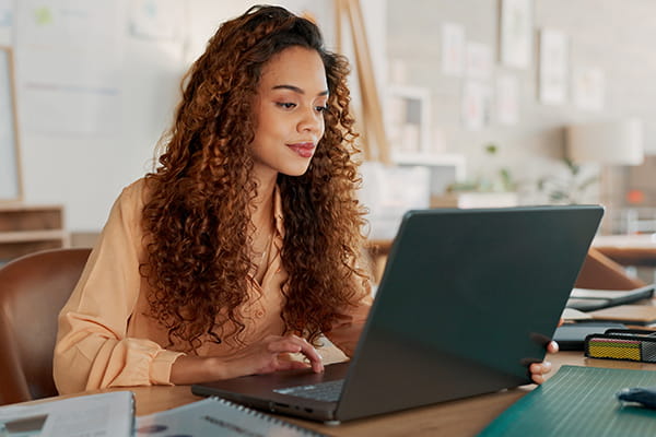 A woman types at her computer