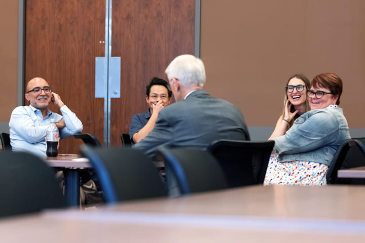 FAPD team members sit around a table to meet a guest speaker